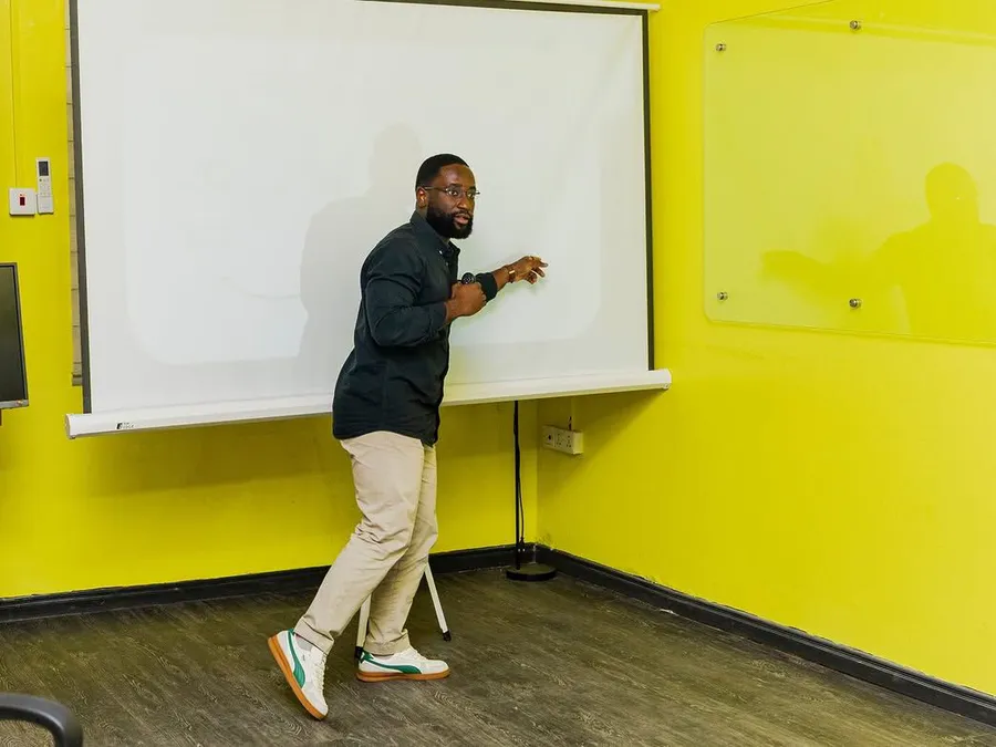 A facilitator at the whiteboard in the workshop room.